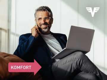 Ein Mann sitzt mit Laptop auf einem Sofa und nutzt zusätzlich ein Smartphone.