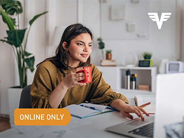 Eine junge Frau tippt mit Kaffeetasse in der Hand auf ihrem Laptop herum.