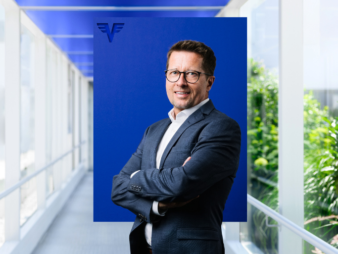 Wolfgang Schöfberger vor blauem Hintergrund.