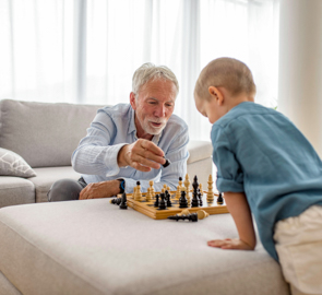 Ein älterer Mann und ein junges Kind spielen Schach.